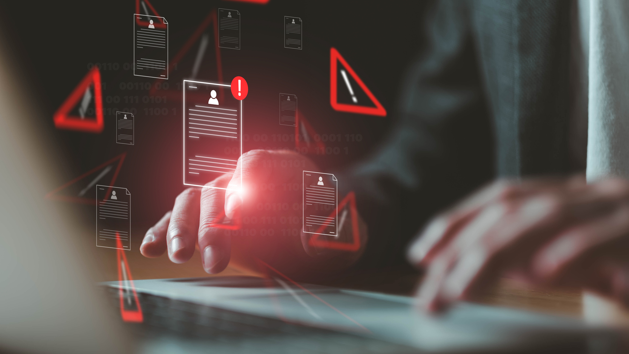 Person typing on a laptop with stylized warning symbols floating above the keyboard