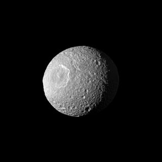 Appearing like a cyclops gazing off into space, Saturn's moon Mimas and its large Herschel Crater are profiled in this view from NASA's Cassini spacecraft taken on Feb. 13, 2010.