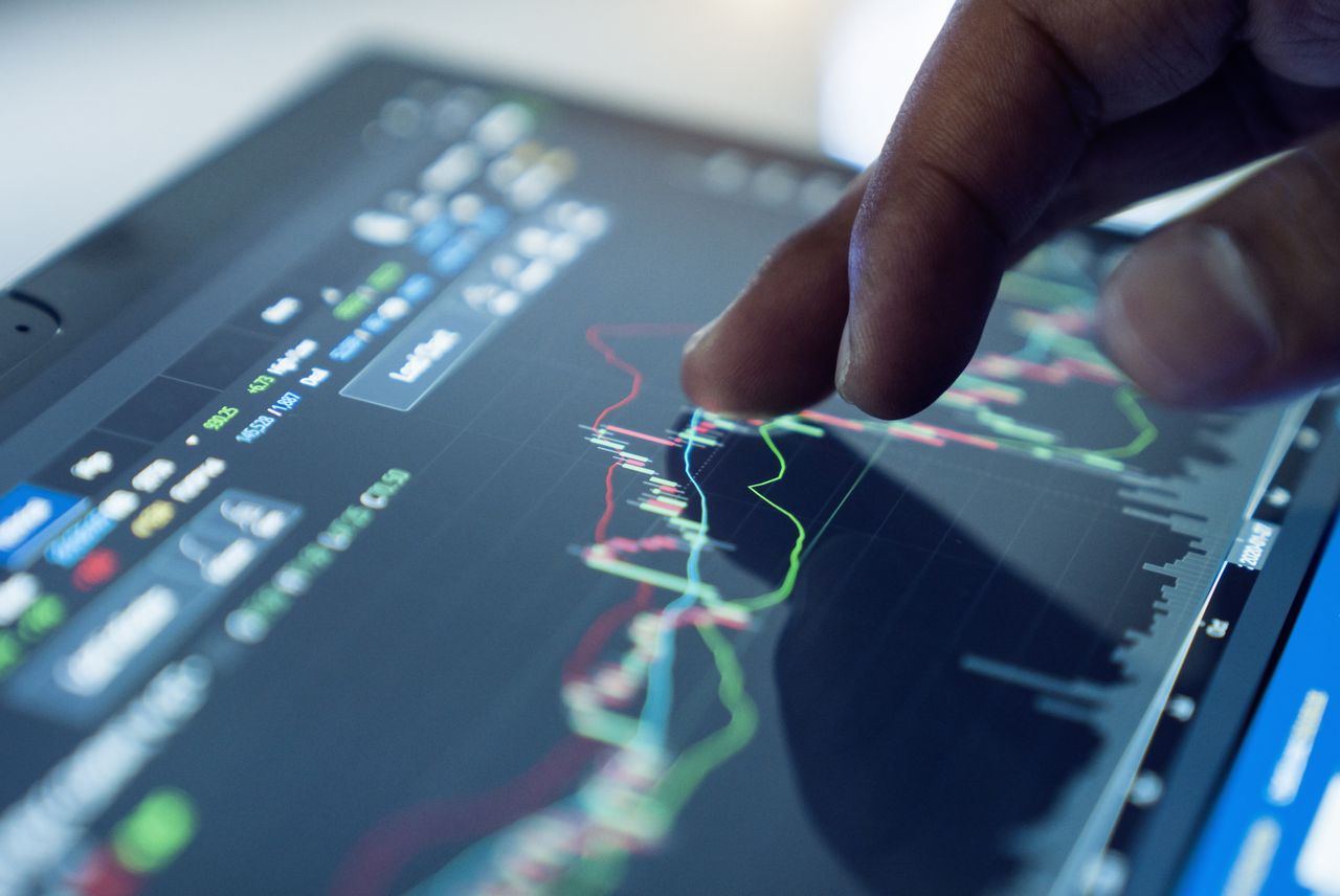 closeup of person touching stock chart on tablet