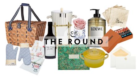 Chic summer hostess gifts, including a picnic basket, pair of oven mitts, table runner, bottle of olive oil, ice bucket, guest book, frame, Venus et Fleur rose, Dutch oven, Loewe hand soap, and more