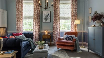 country style living room with navy sofa and orange velvet armchair