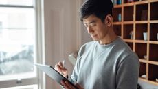 Young man working from home with digital tablet