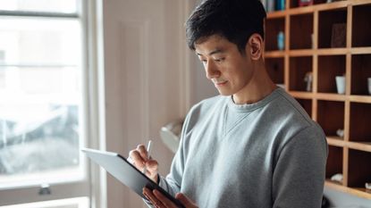 Young man working from home with digital tablet