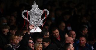 A fan of Kidderminster Harriers holds up a Tin foil FA Cup Trophy during the Emirates FA Cup Third Round match between Kidderminster Harriers and Reading at Aggborough Stadium on January 08, 2022 in Kidderminster, England. 