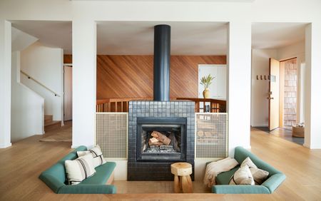 a living room with a conversation pit around a fireplace