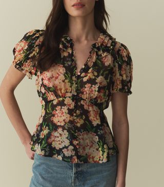 A model wears a floral top and jeans by doen