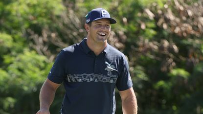 Bryson DeChambeau smiles after hitting putt