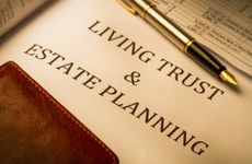 "Living Trust and Estate Planning" printed on paper, with fountain pen and wallet