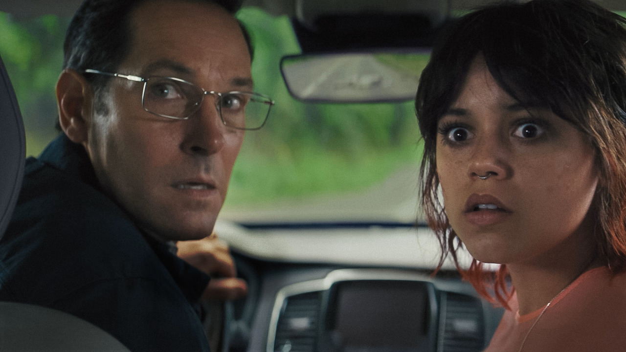 Elliot and Ridley looking scared as they look behind them through a car&#039;s back windscreen in Death of a Unicorn