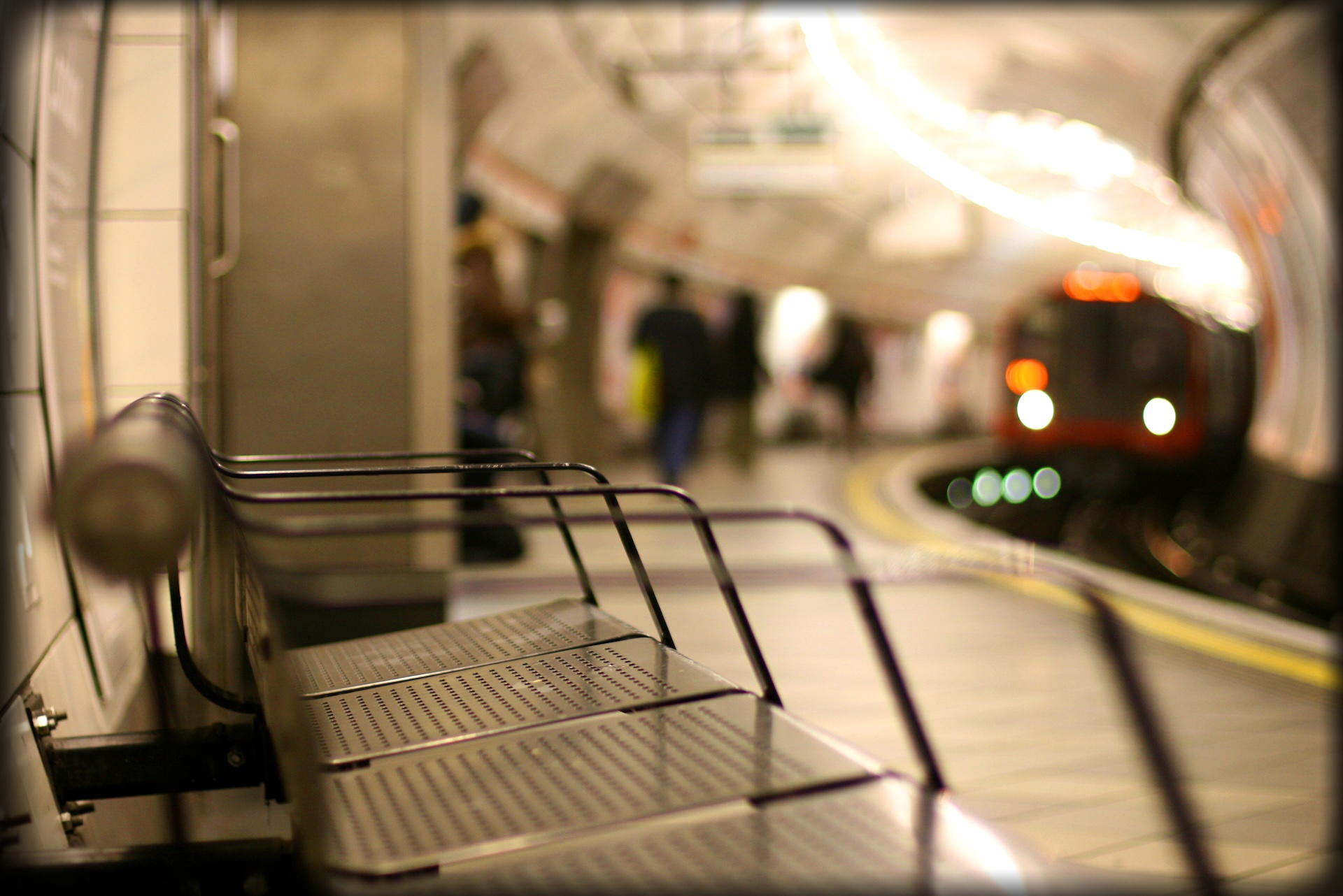 Empty bench in contrast with the approaching train while the city wakes up