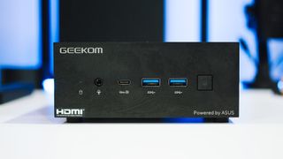 Geekom AS 6 on a white table with RGB lighting in the back