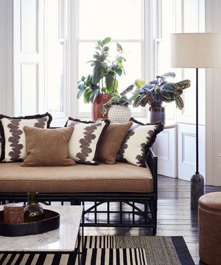 Brown living room with white walls, striped rug and animal print cushions