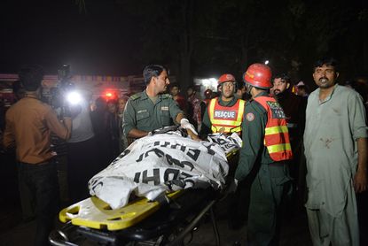 Rescuers help a victim of the bombing in Lahore.
