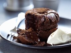 Dark chocolate fondant puddings on a place with slice taken out