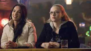 (L, R) Megan Fox as Jennifer Check and Amanda Seyfried as Anita "Needy" Lesnicki seated at a bar counter in Jennifer's Body