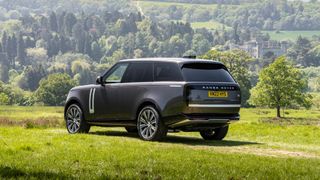 New Range Rover in a field with a castle in the background