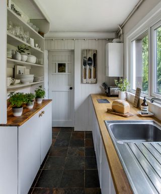 Small galley kitchens example in white with wooden countertops.