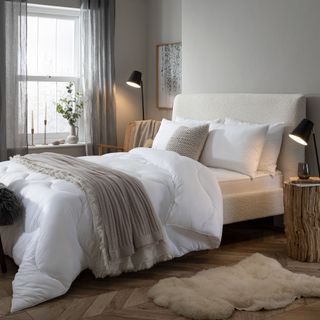 King size bed with white and grey bedding in rustic bedroom setting