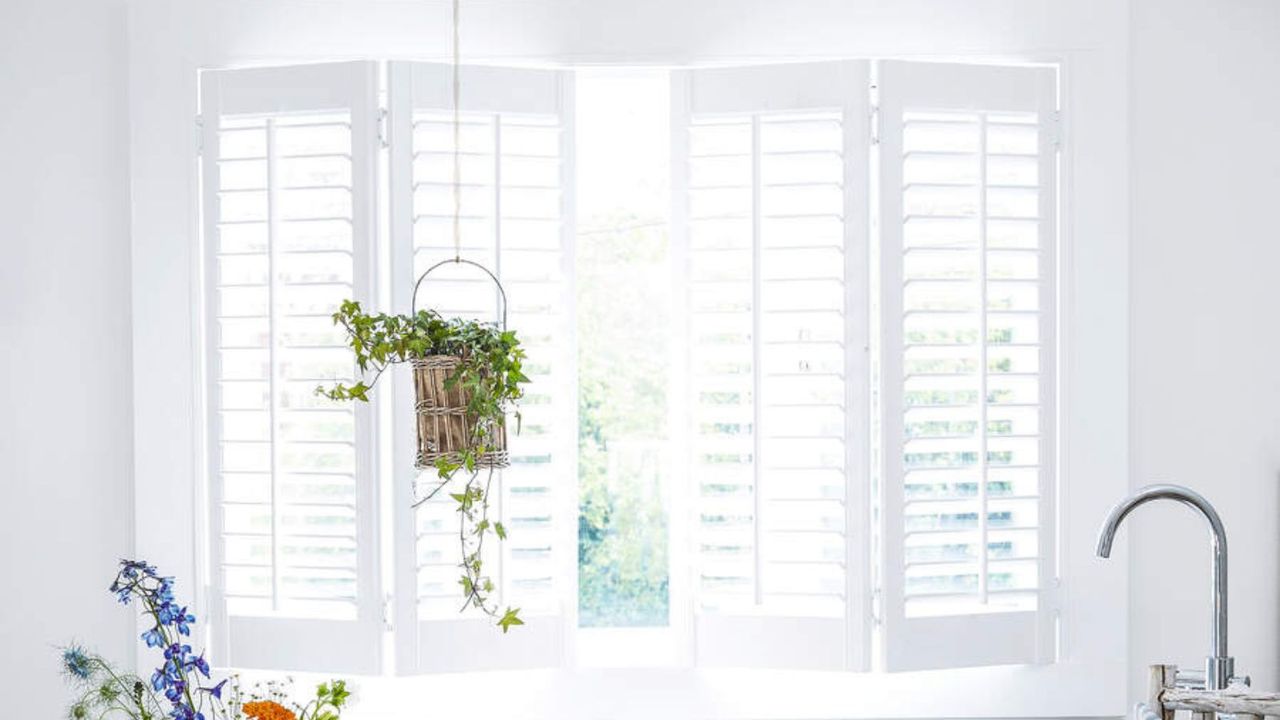 Open bathroom shutters in a bright white bathroom