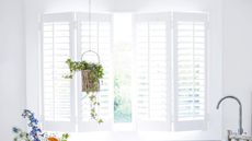 Open bathroom shutters in a bright white bathroom