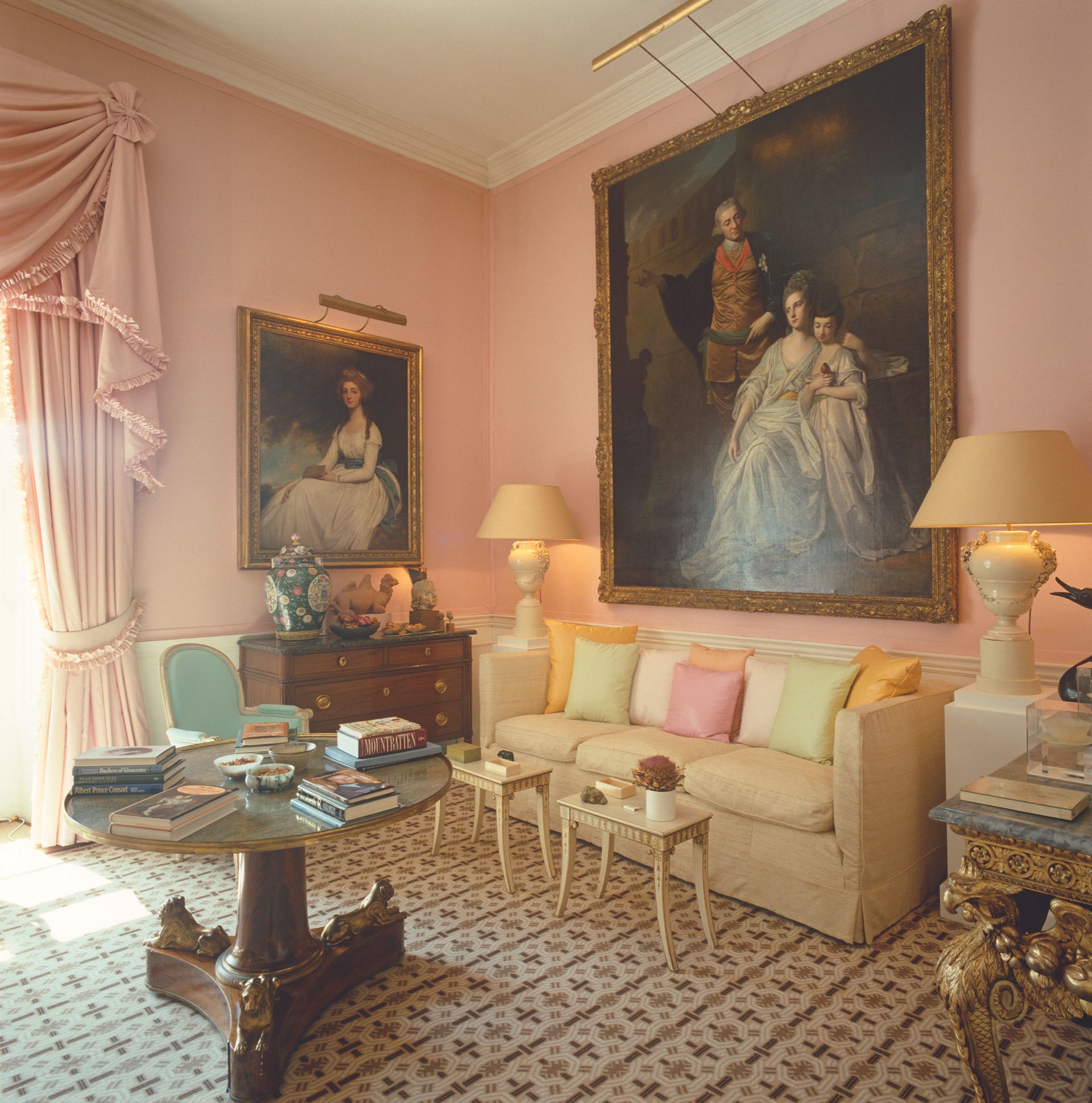 The drawing room is a combination of elegant antique furniture and artwork matched with strong, geometrically patterned carpet and pastel cushions