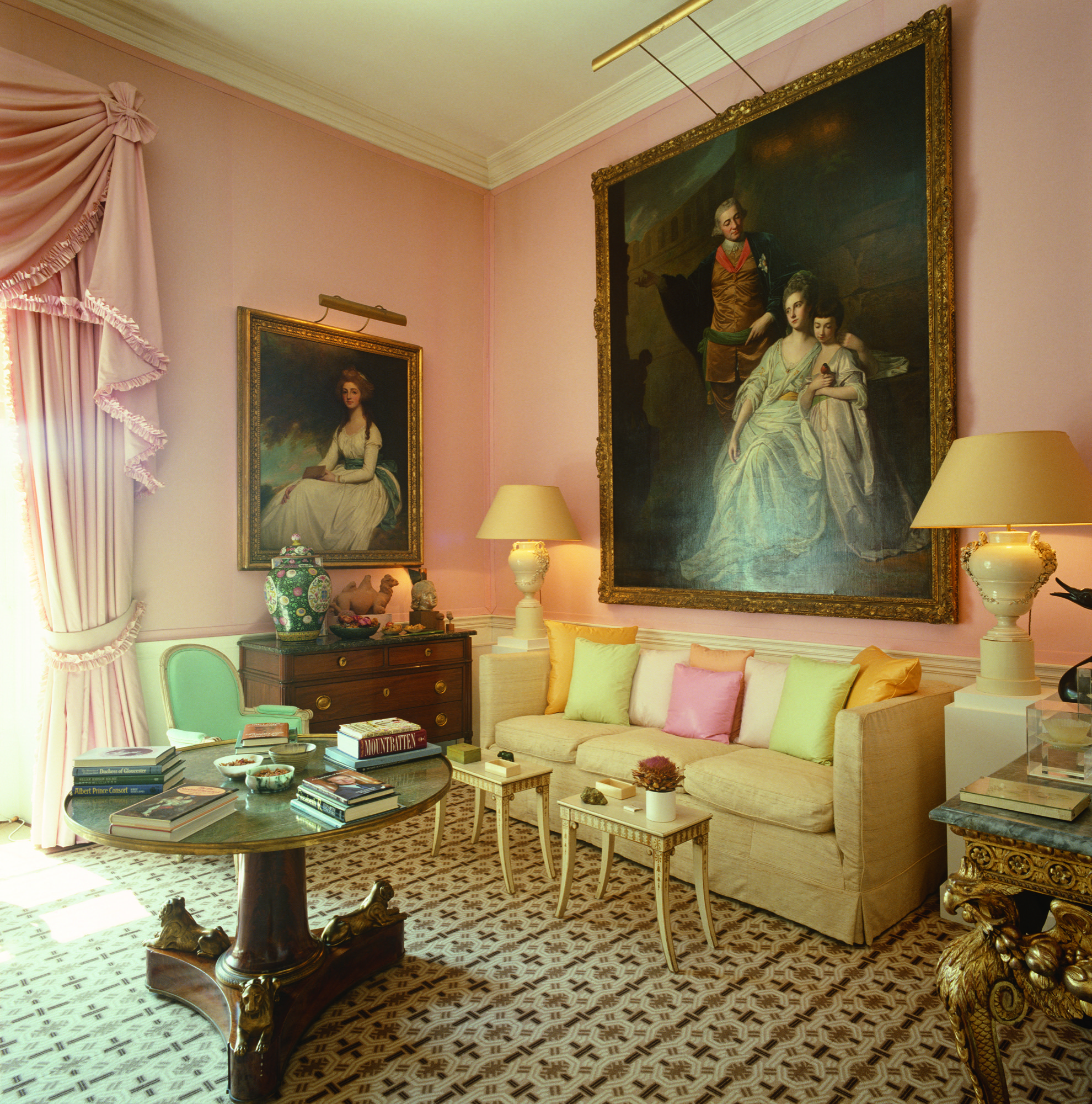 The drawing room is a combination of elegant antique furniture and artwork matched with strong, geometrically patterned carpet and pastel cushions
