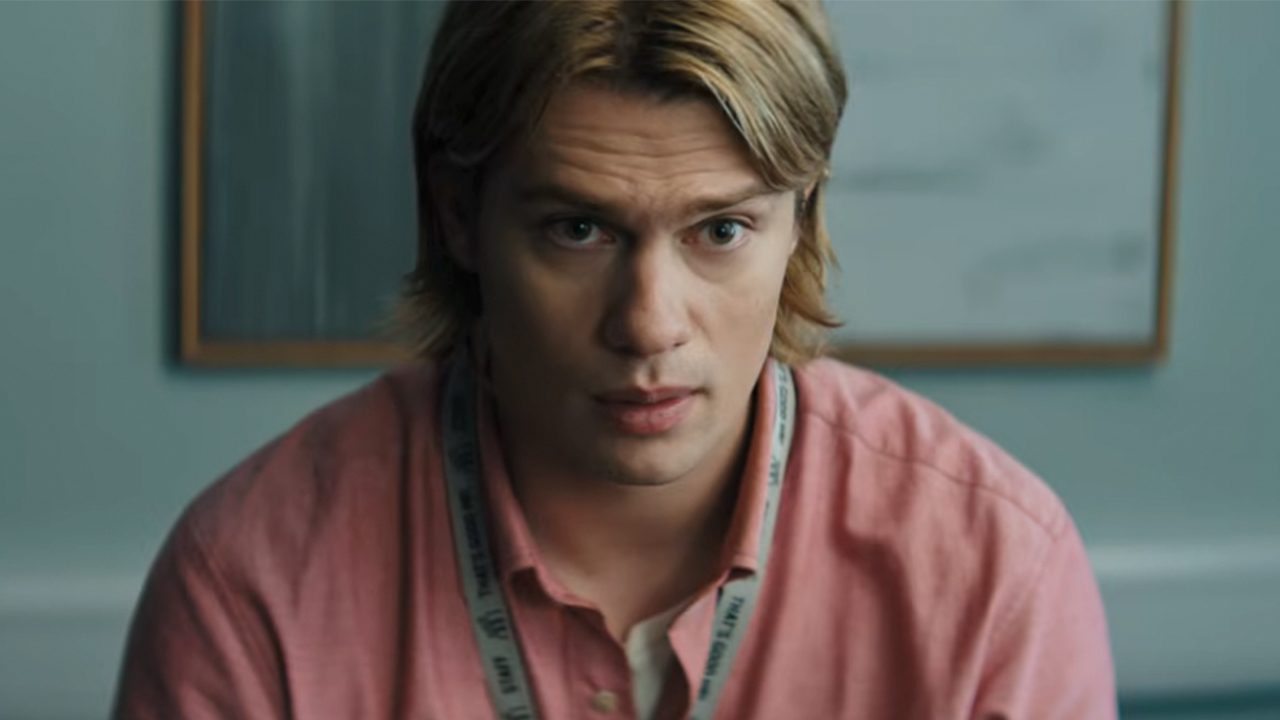 A close up of Nicholas Galitzine as Adam, wearing a pink shirt, in Masters of the Universe