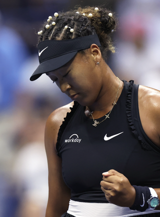 Naomi Osaka wears a black nike tennis set with pearls in her hair