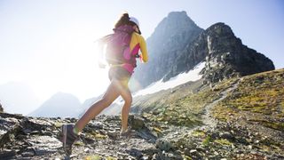 A woman trail running in the mountains