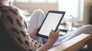 A photo of a woman reading an iPad