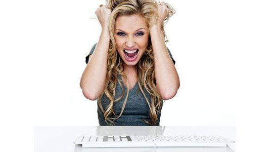 frustrated woman pulling hair at computer