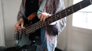 Generation Z Music Band On Rehearsal. Selective focus on girl with bass guitar.