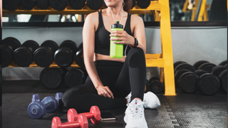 woman sat on floor with dumbbells