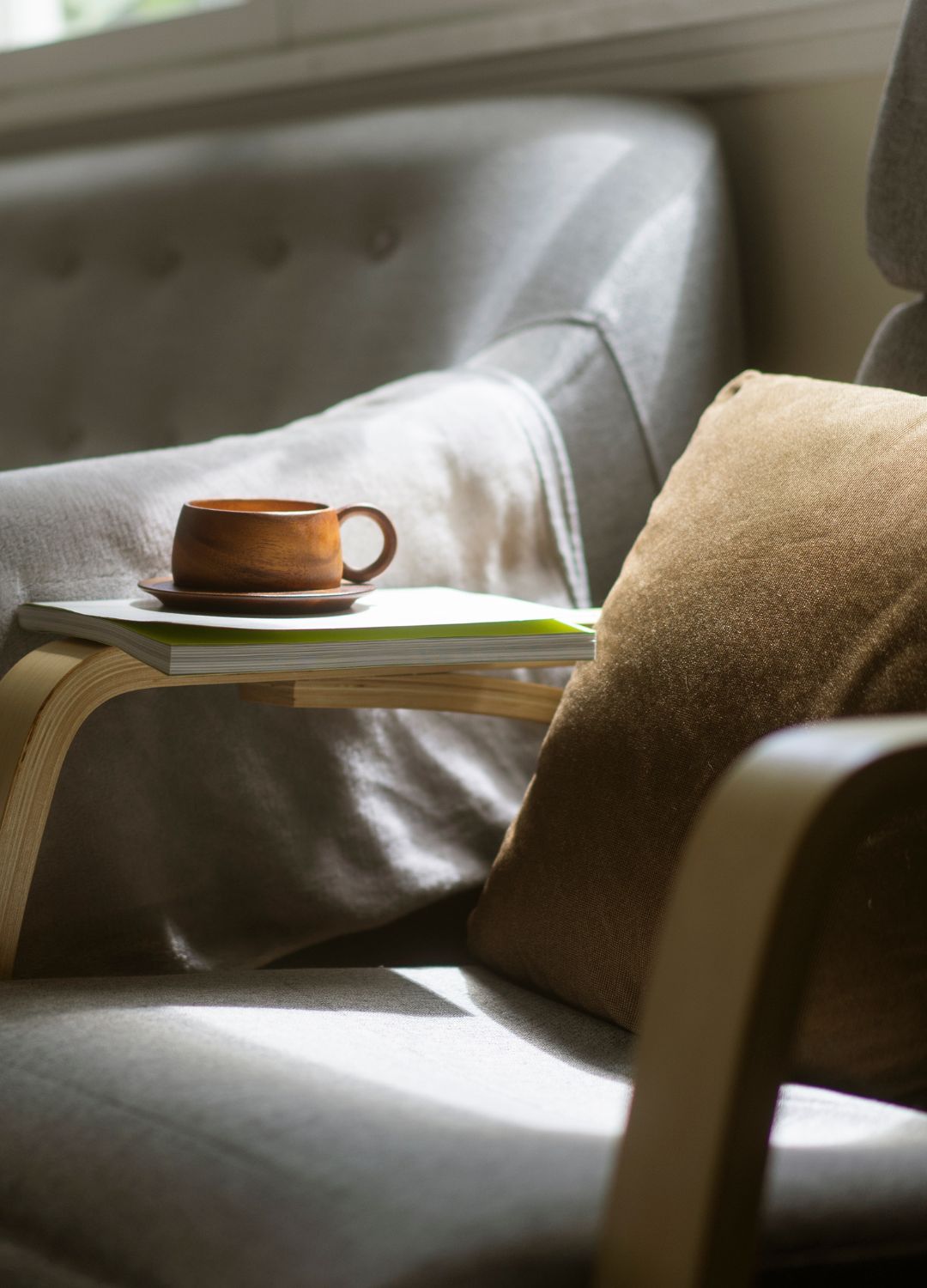 picture of wooden mug on a arm chair with neutral warm toned fabrics