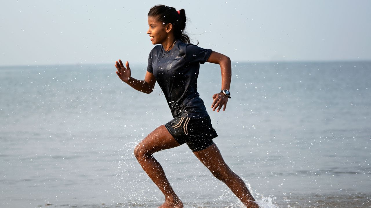 A rugby player works out at the beach