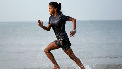 A rugby player works out at the beach