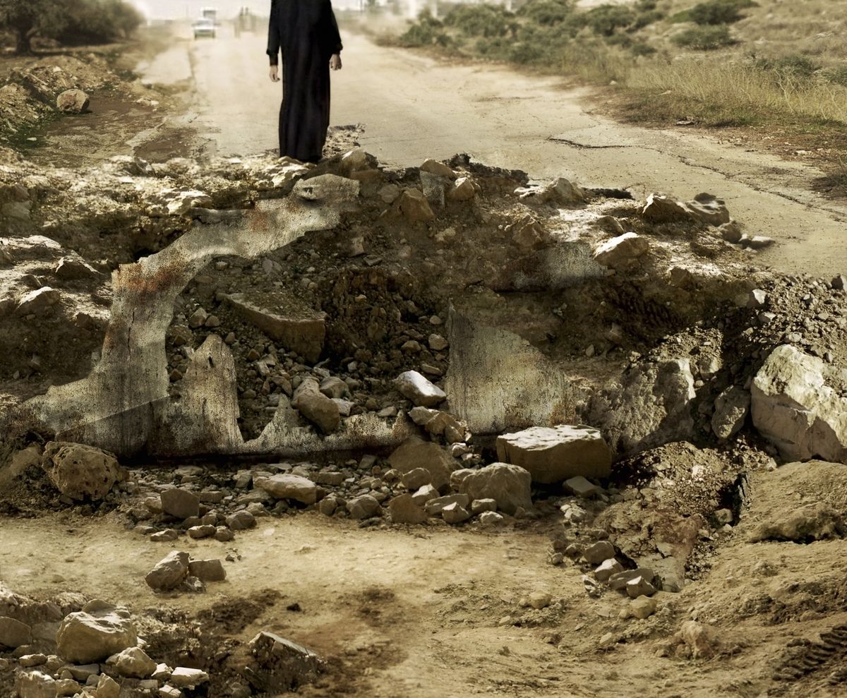 An image by Sophie Ristelhueber of a crater with a person standing on the edge