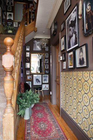 Traditional Victorian-style hallway with patterned wallpaper and a gallery wall