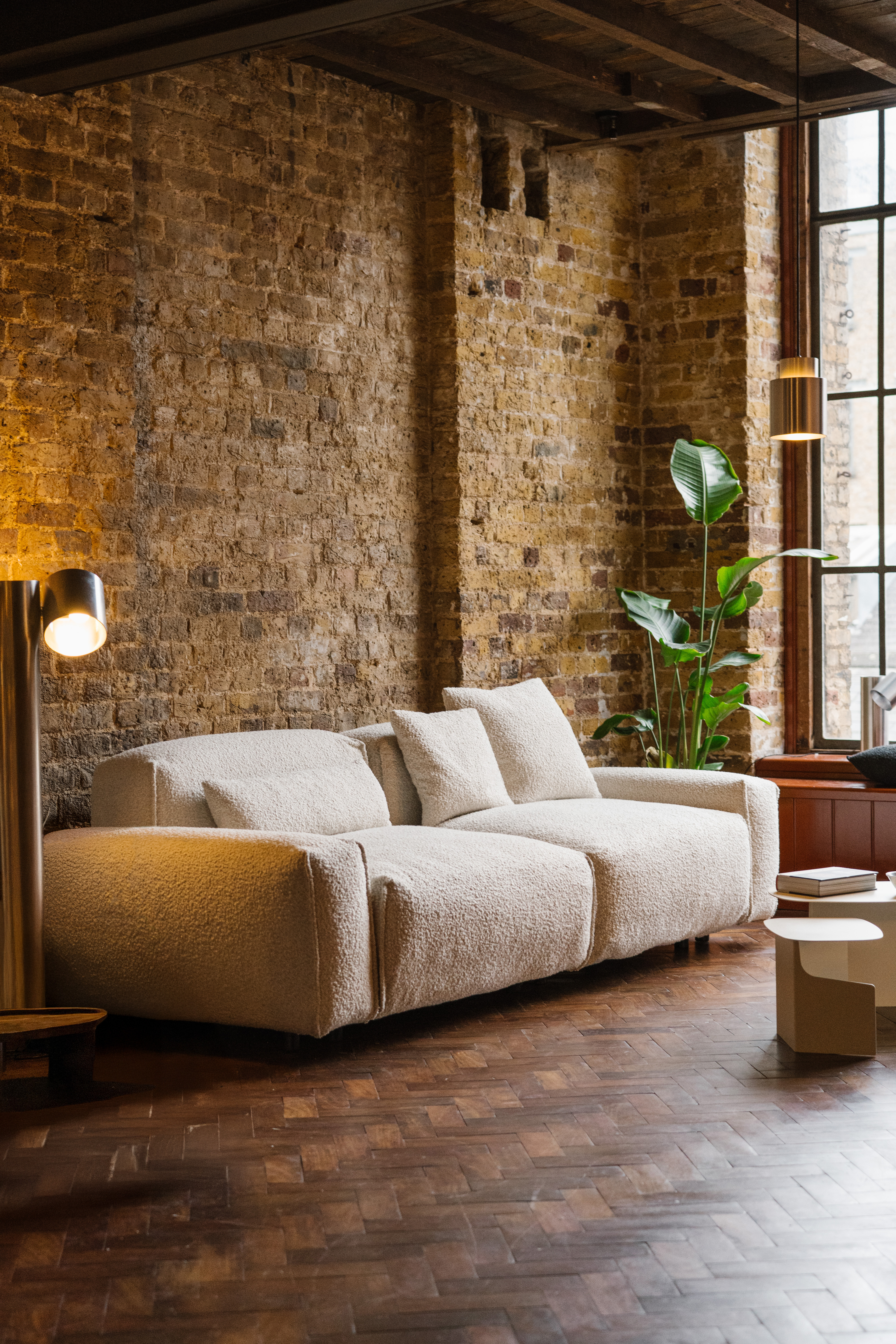 a boucle sofa in a brick industrial showroom