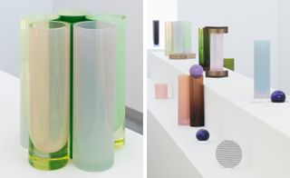 Left: five glass vases in a circle, white surface and background wall. Right: White block platforms with installation of geometric and colourful vessels in enamelled porcelain and iridescent glass objects, white wall background