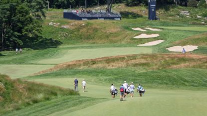 Players walk to the 10th tee during a practice round before the 2022 US Open
