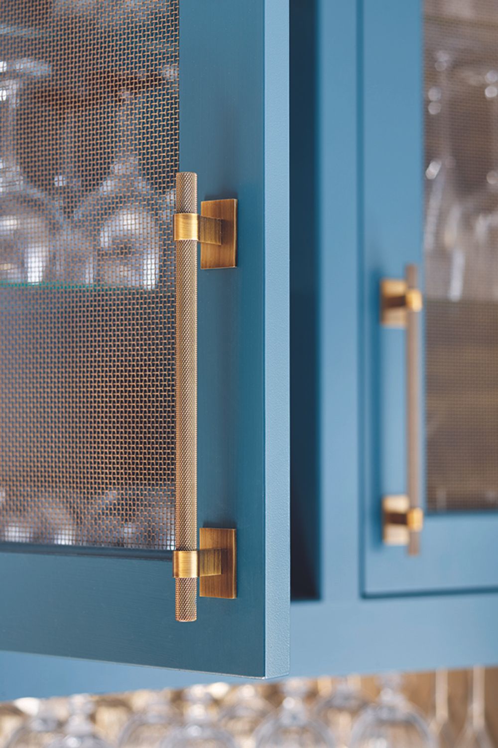 Kitchen trends 2021 showing a close up of mesh cabinets painted in a bold blue with ornate mesh handles