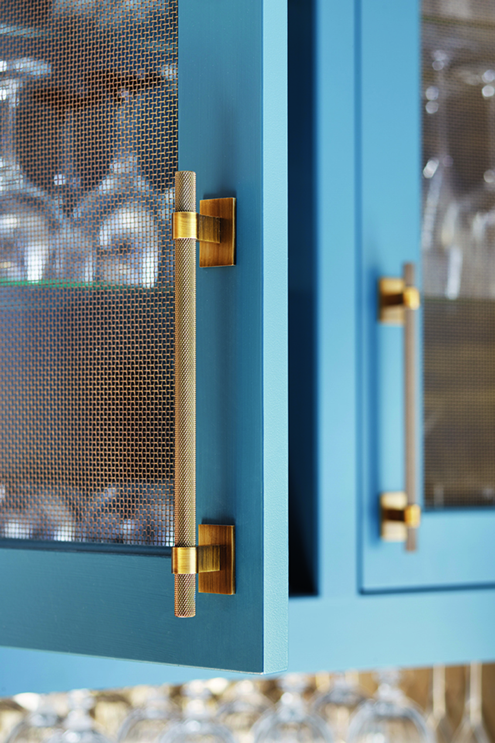 Kitchen trends 2021 showing a close up of mesh cabinets painted in a bold blue with ornate mesh handles