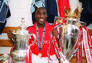 Sol Campbell holds the FA Cup and Premier League trophy, 2002