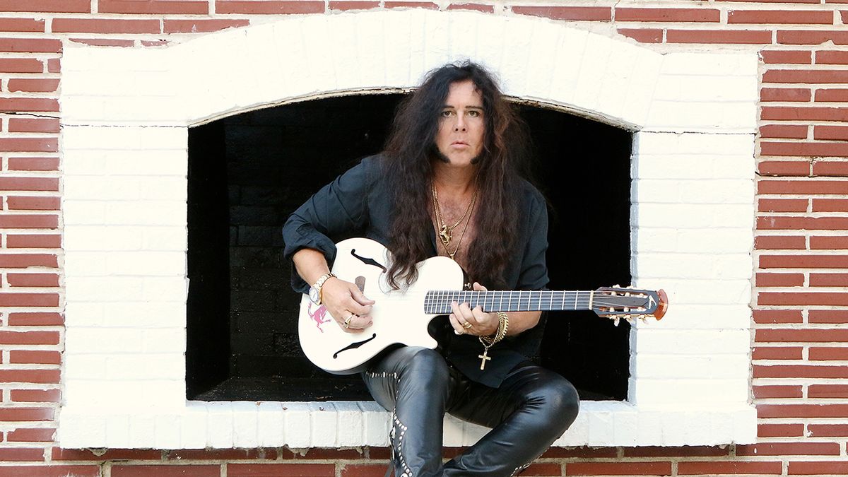 A shot of Yngwie Malsteen sat in a window holding a guitar