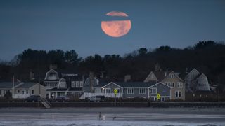 The moon sets after a partial lunar eclipse in November 2021.