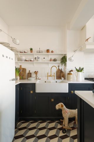 A white and black kitchen with patterned floor tiles and Smeg retro refrigerator appliance