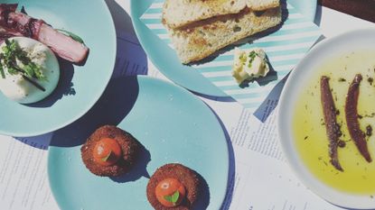 Lydia swinscoe dining alone alongside plates of food across the globe