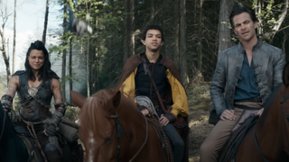 Michelle Rodriguez, Justice Smith and Chris Pine ride horses in front of a forest while a man falls through the air behind them