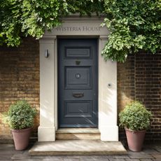 front door colour ideas, Georgian front door painted charcoal grey, planters each side, steps up, wisteria growing above
